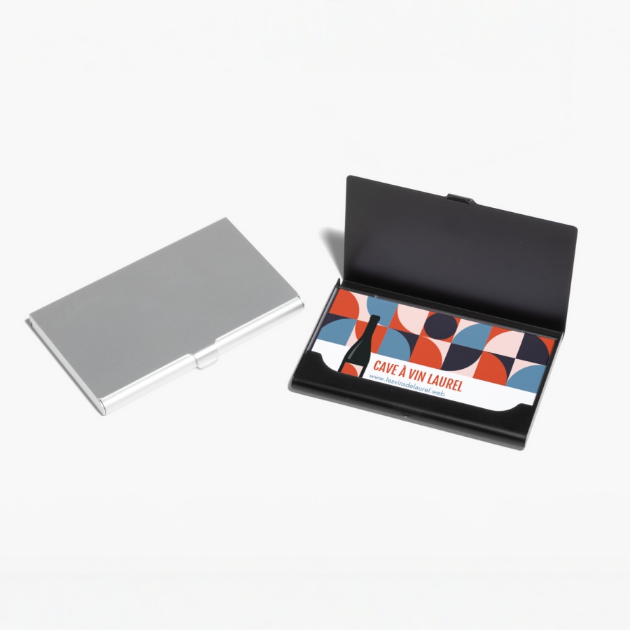 Un porte-cartes d’affaires en aluminium argenté fermé et un porte-cartes d’affaires noir ouvert, laissant apparaître les cartes d’affaires d’une marque de vin.