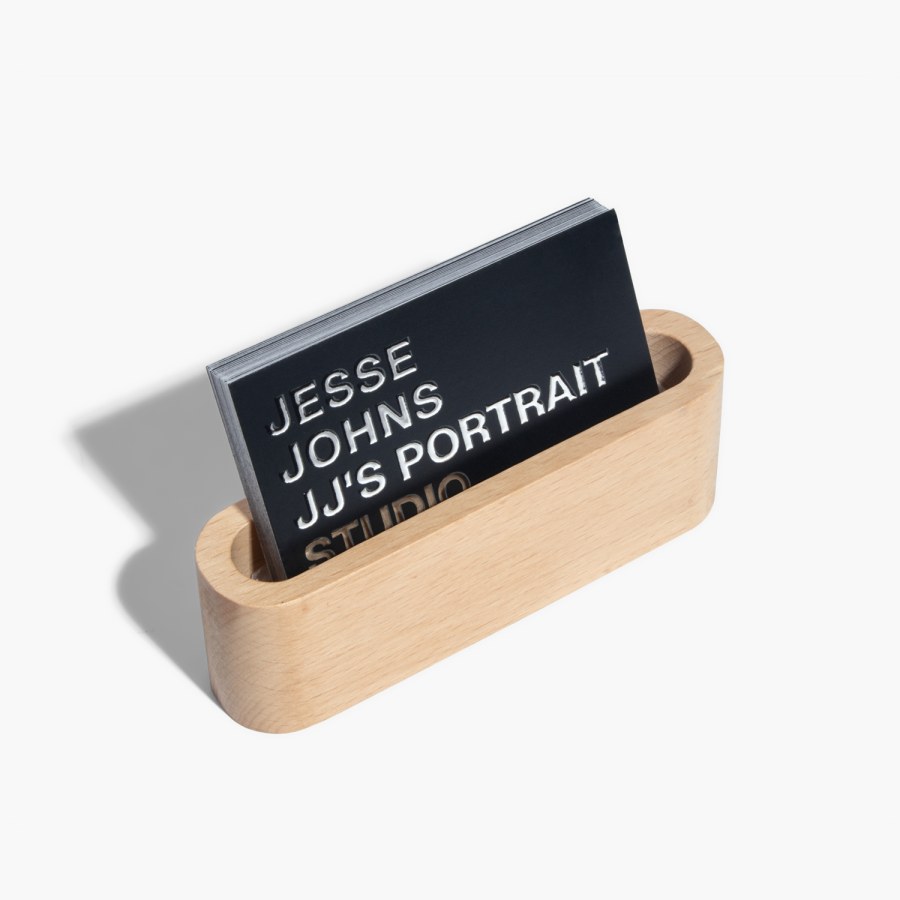 Cartes d’affaires avec effet métallisé en relief faisant la promotion d’un studio de portrait, dans un support en bois