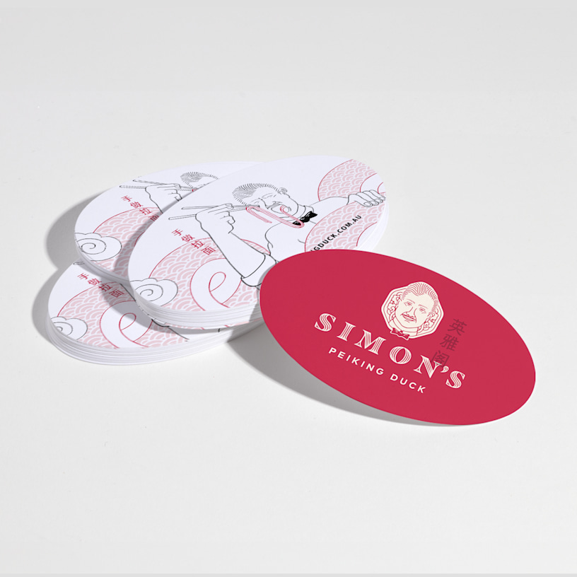 Une pile de cartes d’affaires ovales pour un restaurant, avec des vues du recto et du verso.