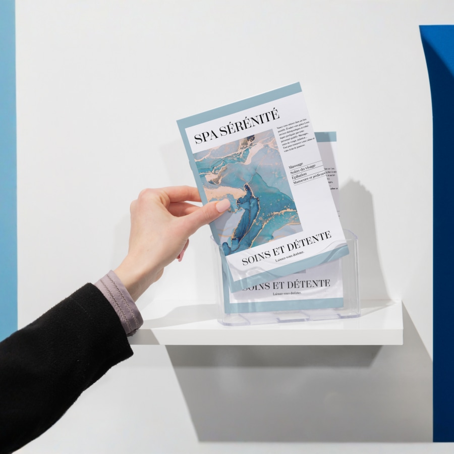 Une personne qui prend un livret avec agrafage à cheval pour un spa dans un porte-livret.   