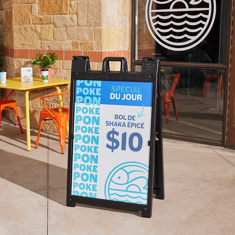  Un panneau SignicadeMD noir sur un trottoir faisant la promotion d’un poke bowl spécial.