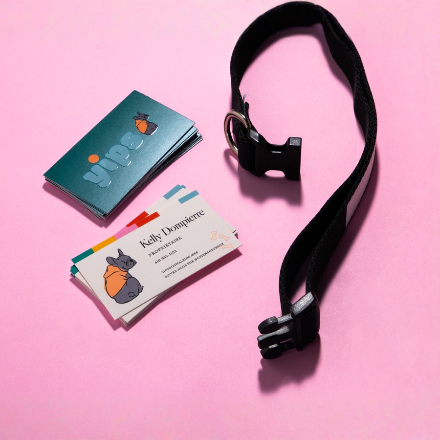 Deux piles de cartes d’affaires avec fini brillant en relief, montrant le graphisme recto et verso d’une entreprise offrant un service de promenade canine. Un collier pour chien est posé à côté.