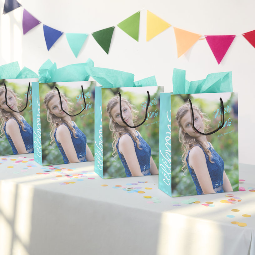 Montre une gamme de sacs multicolores étalés en éventail avec les mots Tennis Club imprimés dessus. 