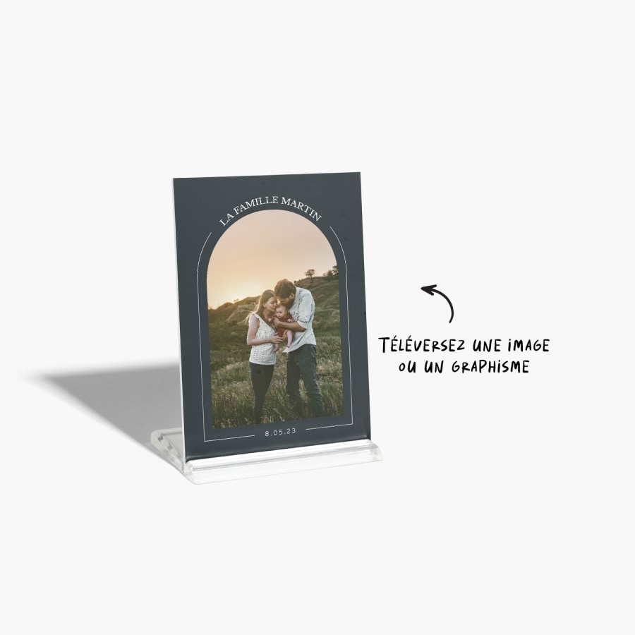 Une plaque photo sur laquelle est imprimée une photo d’un couple et de son bébé. La photo est encadrée d’un motif d’arc.