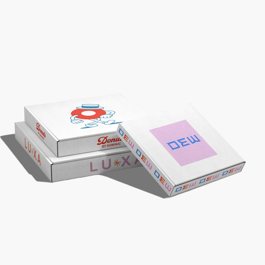 Trois boîtes carrées pour envoi postal avec logo posées à plat, arborant des logos colorés sur le dessus.