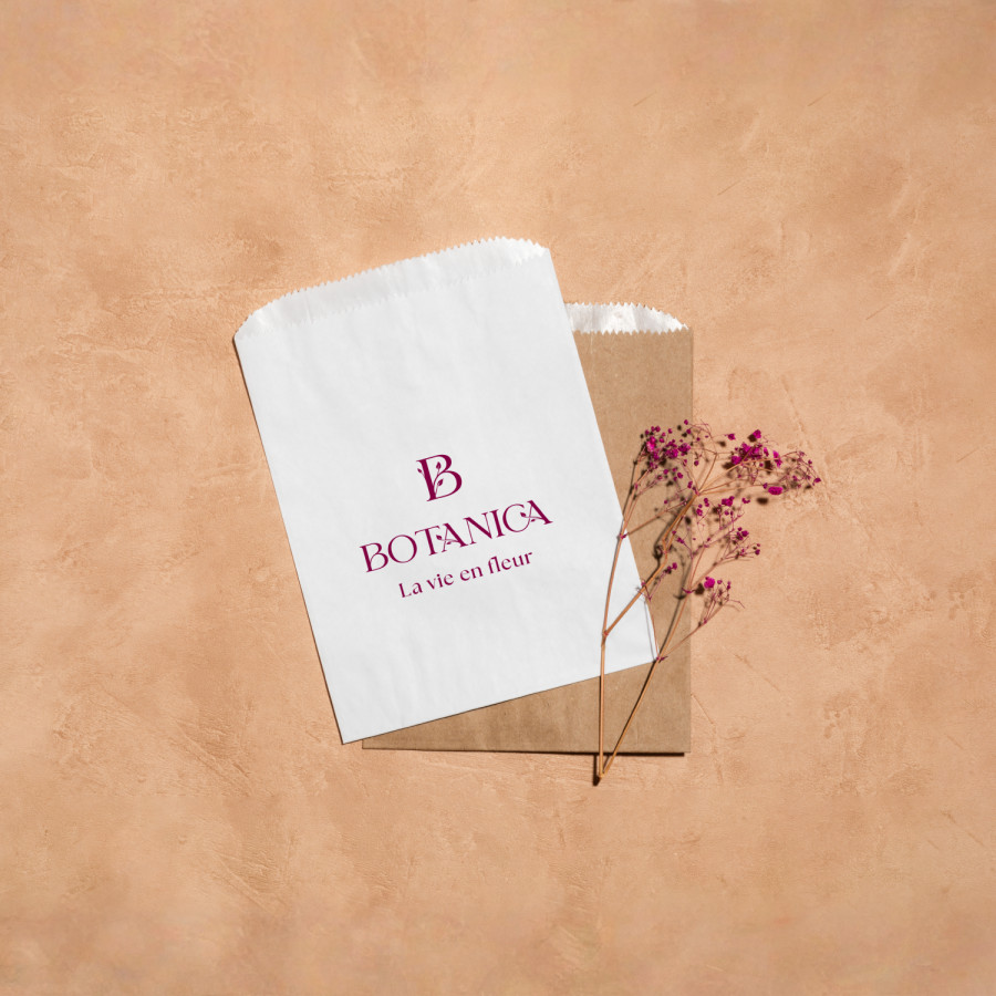 Deux sachets de friandises, l’un en papier blanc, l’autre en kraft, faisant la promotion d’une fleuristerie.