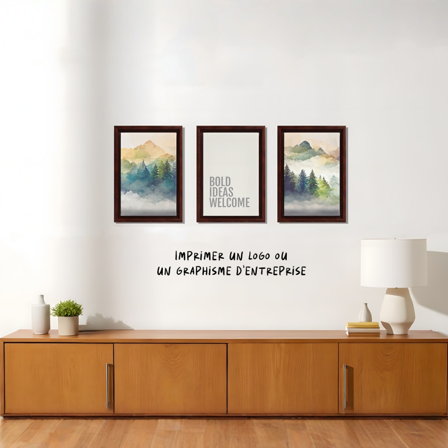 Trois toiles encadrées accrochées au mur d’un salon; l’une porte la phrase « Les idées audacieuses sont les bienvenues ». 