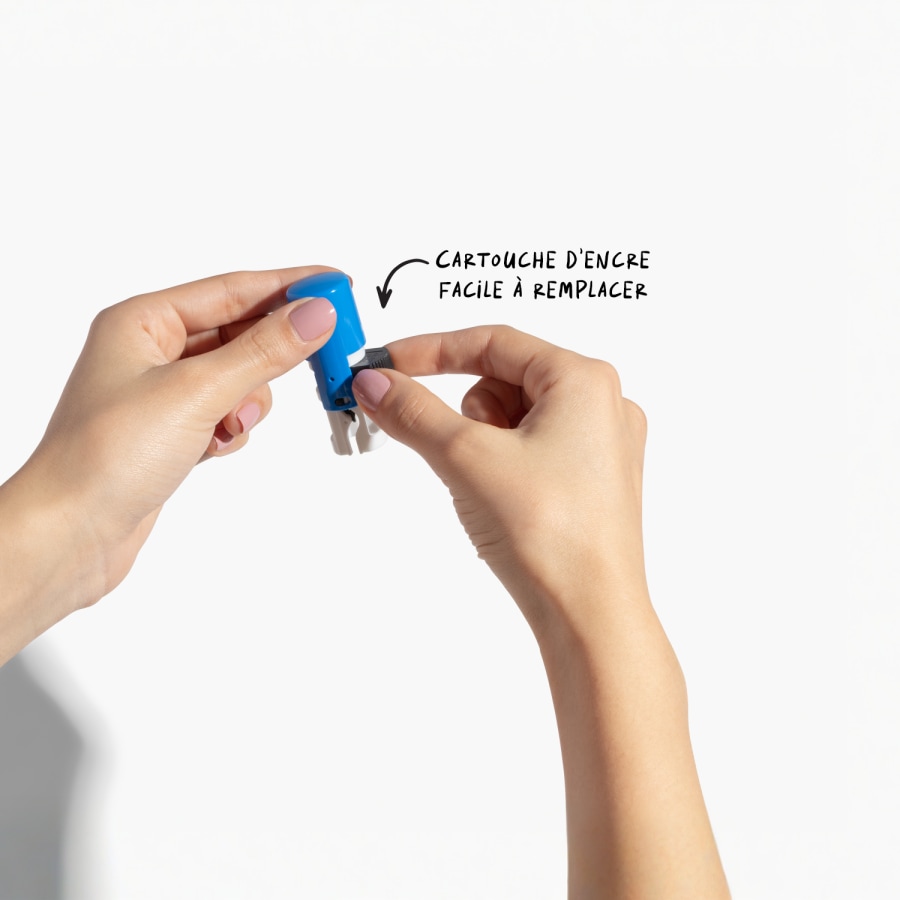 Une personne en train de changer le coussin encreur d’un petit tampon encreur rond, avec une note indiquant que le coussin est facile à changer.