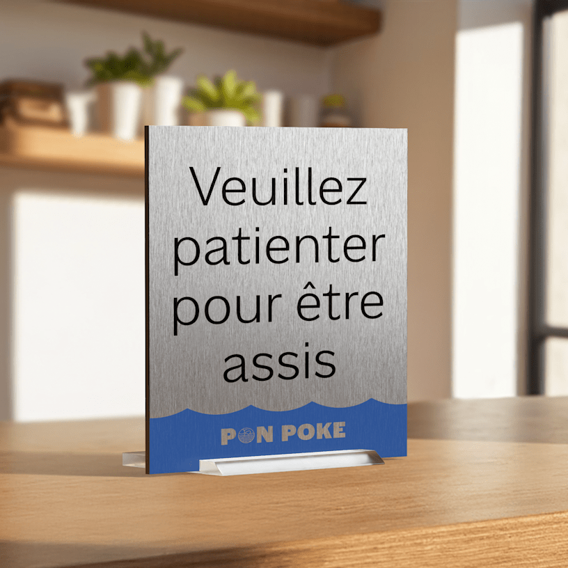  Une pancarte de table en métal placée dans un restaurant de pokés invite les clients à attendre qu’on les installe.