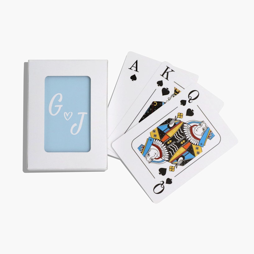 Une pile de cartes à jouer personnalisées avec un monogramme de mariage et un détail en forme de cœur. 