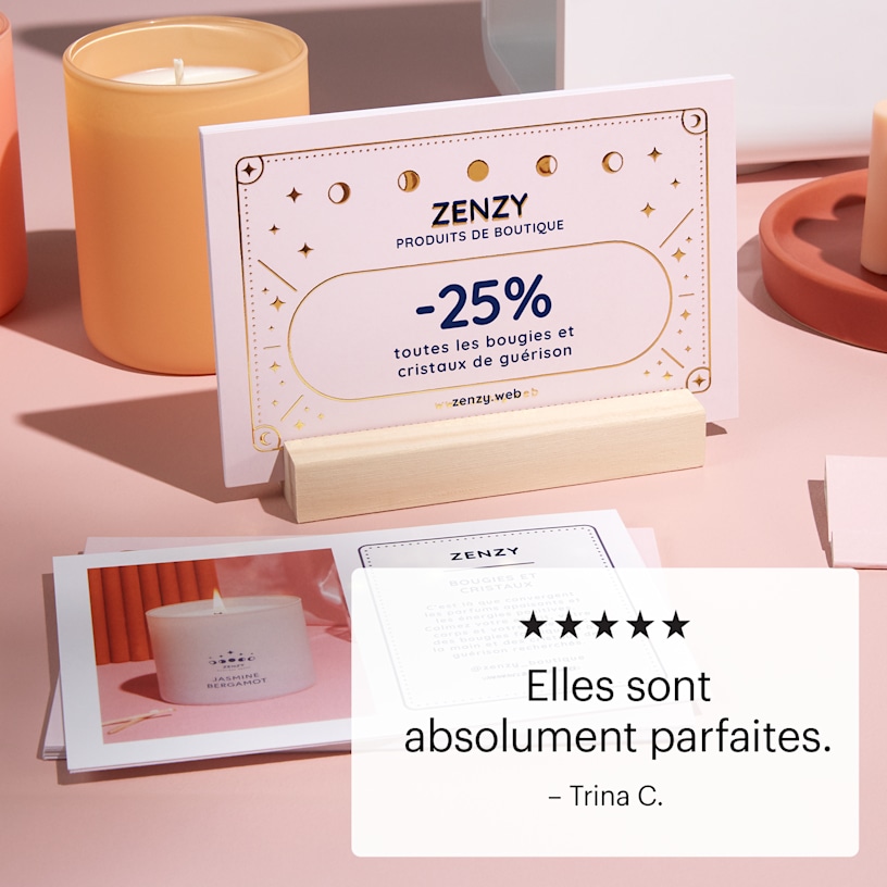 Une carte postale avec effet métallisé en relief, rangée dans un support en bois sur un comptoir de présentation.