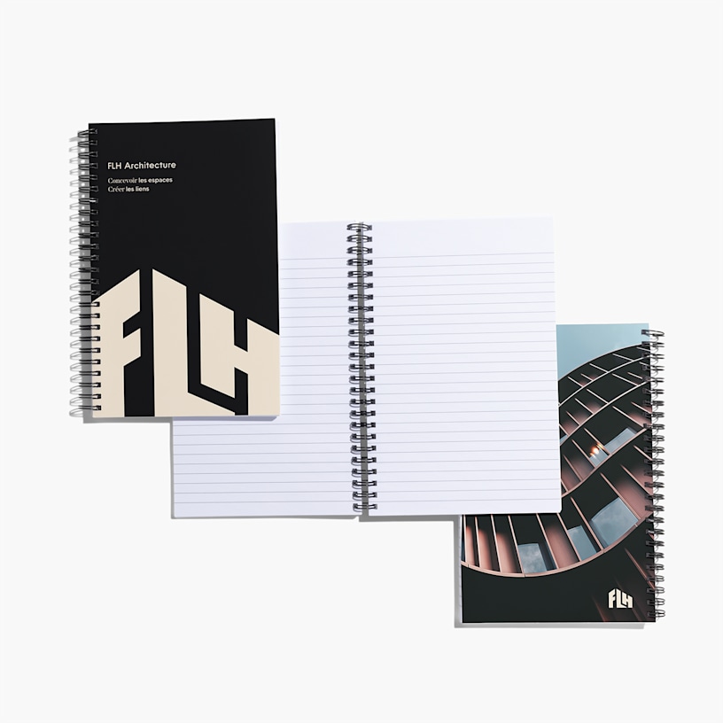 Deux cahiers fermés et un ouvert présentant une réglure à points.