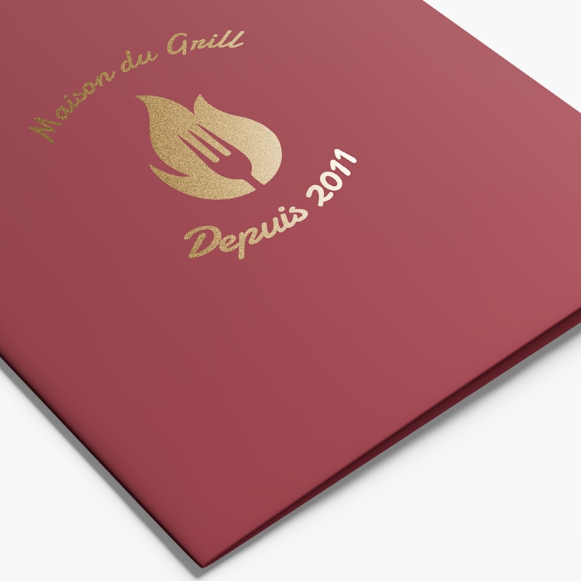 Une chemise de présentation rouge d’un restaurant, avec son nom et son logo, le tout avec un effet métallisé doré.