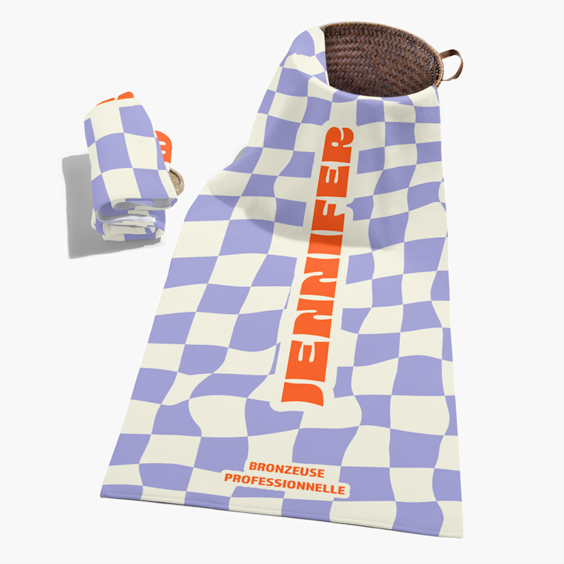 Une serviette personnalisée imprimée d’un motif à carreaux violets et d’un nom. 