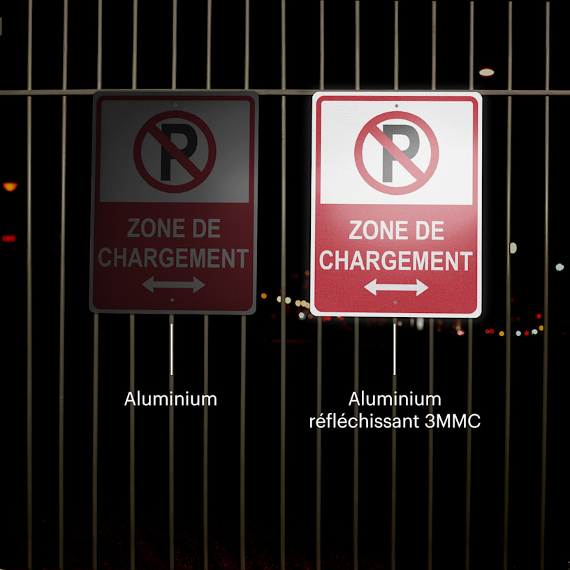 Deux pancartes de stationnement accrochées à une clôture visibles de nuit.