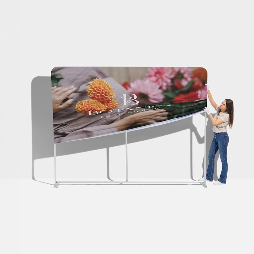 Une femme en train d’installer le tissu sur la structure en aluminium du stand tubulaire.