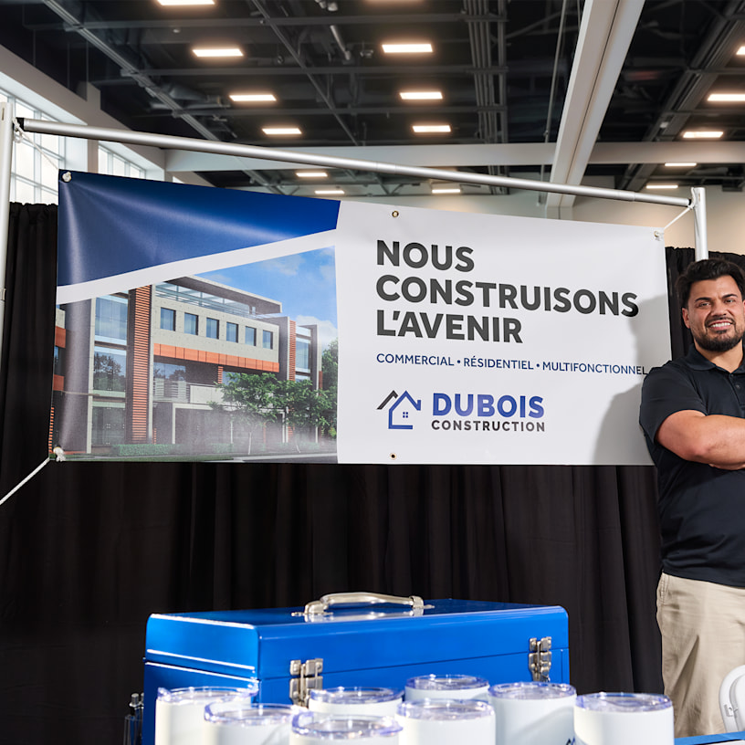 Une banderole colorée en vinyle, suspendue et faisant la promotion de beignes gratuits.