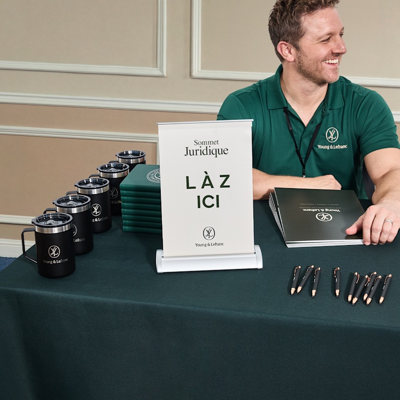  Une banderole rétractable de comptoir faisant la promotion d’un sommet juridique lors d’un salon professionnel.