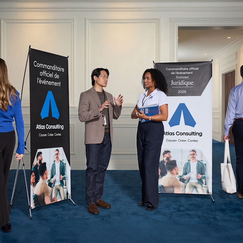  Un homme et une femme devant deux banderoles en X lors d’un salon professionnel.