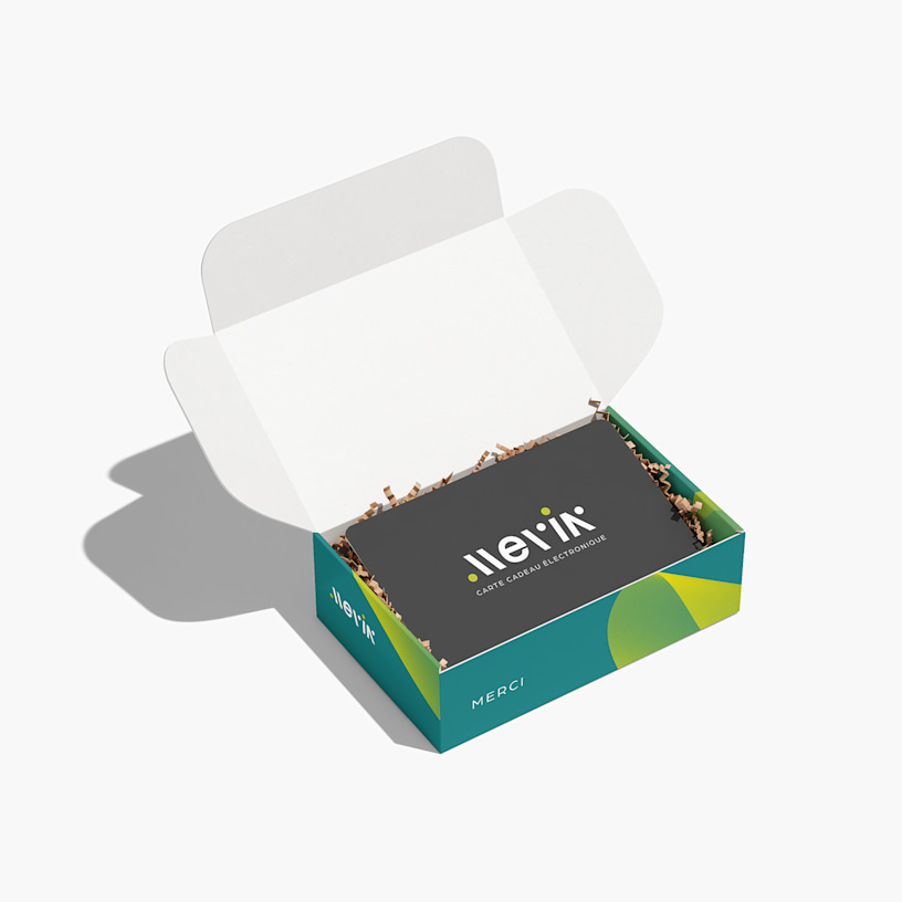Une miniboîte pour carte-cadeau ouverte avec une carte-cadeau à l’intérieur, sur du papier plissé.