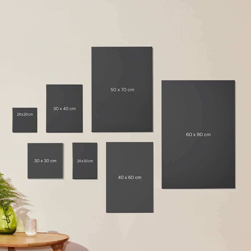 Photos sur toile pêle-mêle assorties accrochées à un mur, avec dimensions.