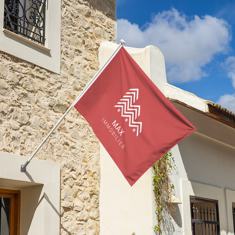 Le drapeau d’un agent immobilier flottant au-dessus d’une maison.
