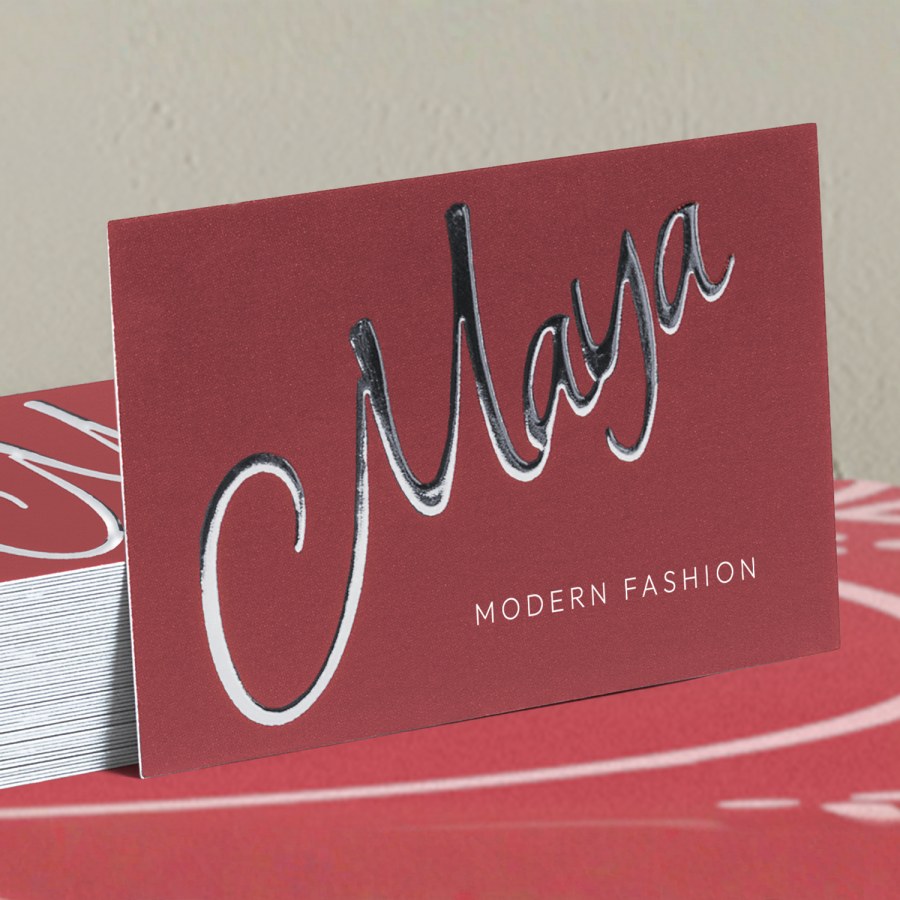 Pile de cartes de visite effet métallisé argenté en relief d’un magasin de vente au détail.