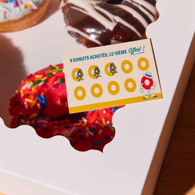 Une carte de fidélité pour une boutique de donuts avec des perforations indiquant la progression jusqu’à la récompense.
