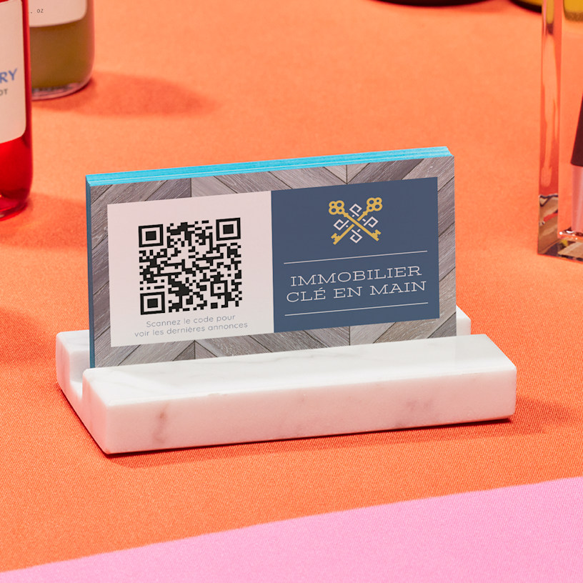 Un porte-cartes en marbre contenant des cartes de visite avec code QR pour une personne nommée Raúl Benítez.