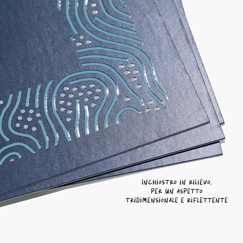 Un primo piano raffigurante dei biglietti da visita con vernice UV e lettere lucide in rilievo dall’effetto riflettente 3D.