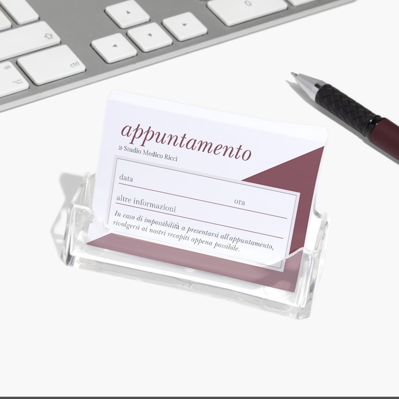 Un portabiglietti da visita in acrilico contenente dei biglietti per appuntamenti di una clinica medica.
