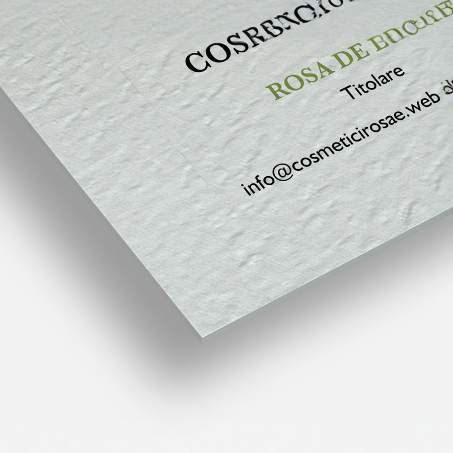 Primo piano su dei biglietti da visita in carta ruvida non patinata che ne mette in evidenza gli angoli squadrati e la particolare trama del materiale che ricorda quella della tela.