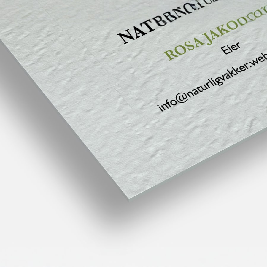 Et nærbilde av visittkort av ubestrøket papir som viser de rette hjørnene og den lerretsaktige papirkvaliteten.