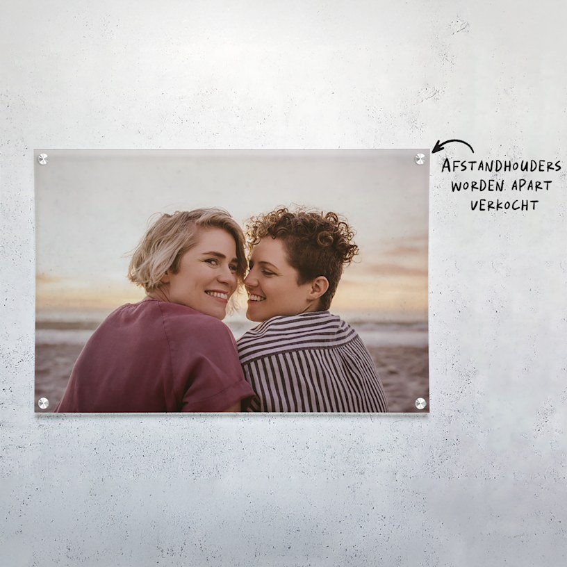 Een foto op acrylglas van een jong stel op het strand. 