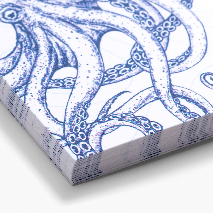 Een close-up van een stapel gerecycled matte visitekaartjes, voorzien van een ontwerp met een inktvis.