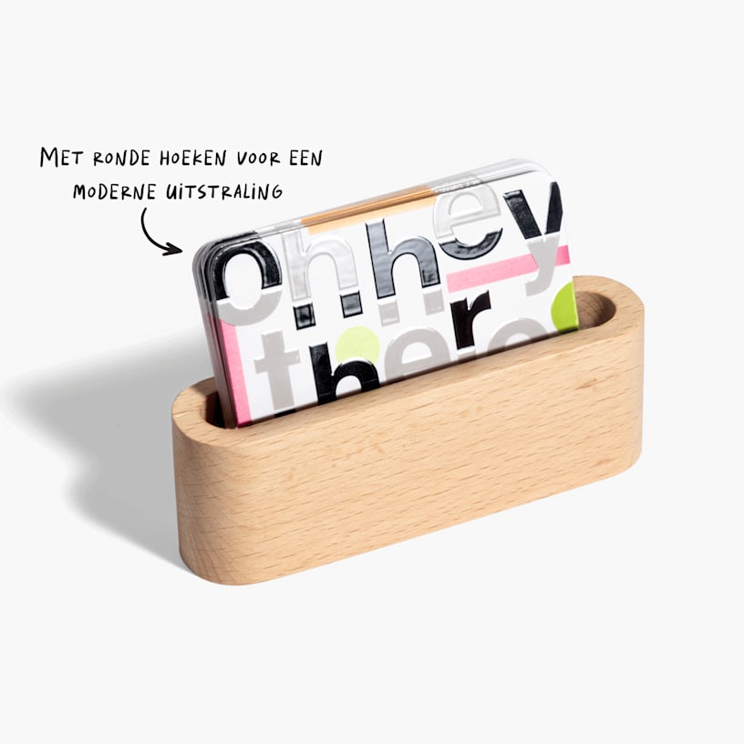 Een stapel visitekaartjes met spot-UV en ronde hoeken in een houten houder.