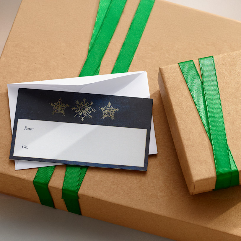 Uma etiqueta para presente personalizada com design de Natal e um envelope branco simples. 