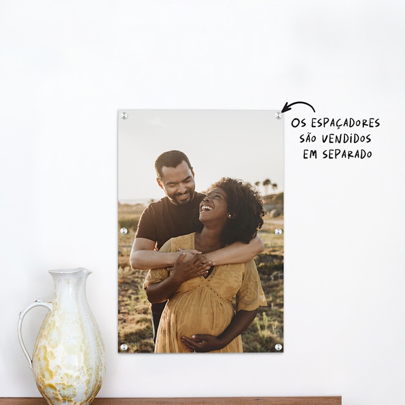 Uma impressão em acrílico que mostra a fotografia de maternidade de um jovem casal. 