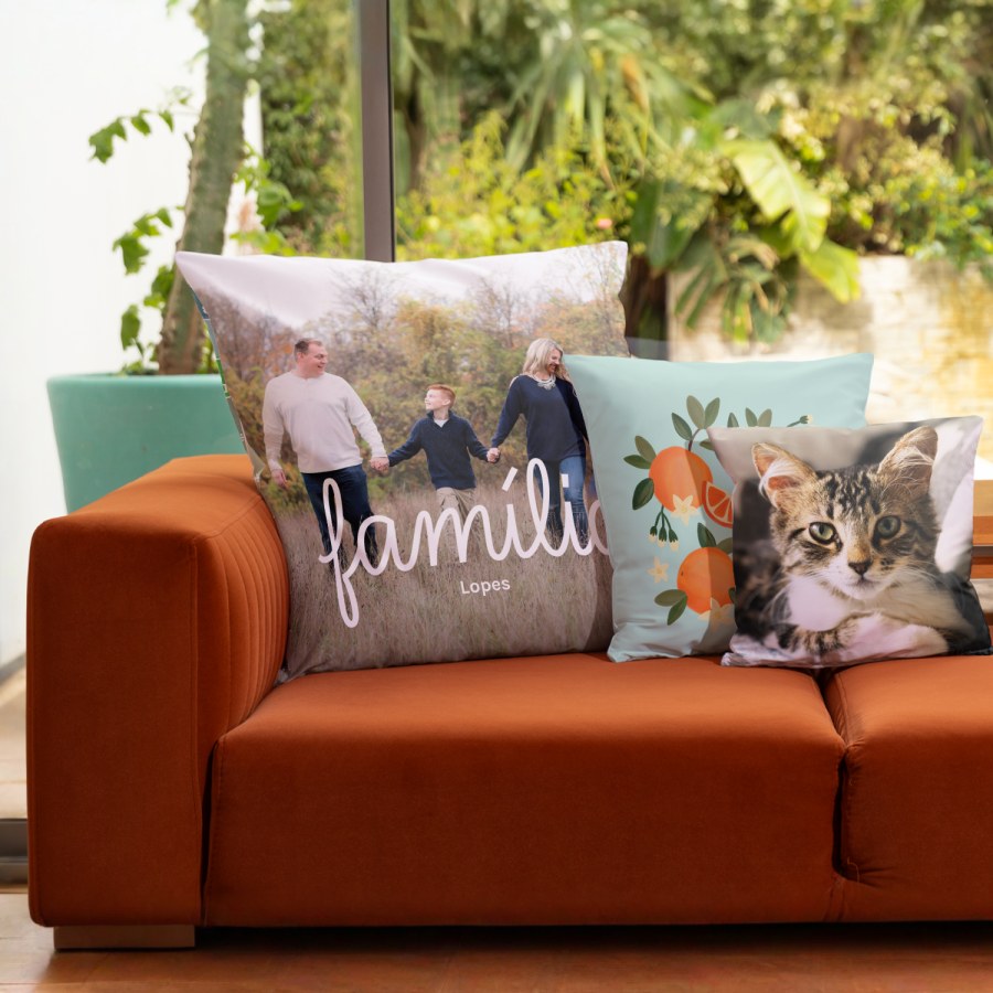 Três almofadas personalizadas com uma fotografia de família, um design baseado numa imagem com laranjas e a fotografia de um gato. 