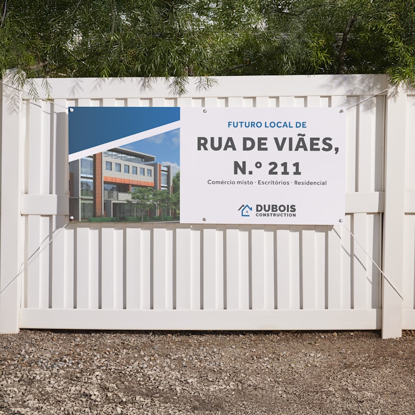 Lona publicitária de uma empresa de construção, presa a uma vedação, com informações sobre o novo edifício.