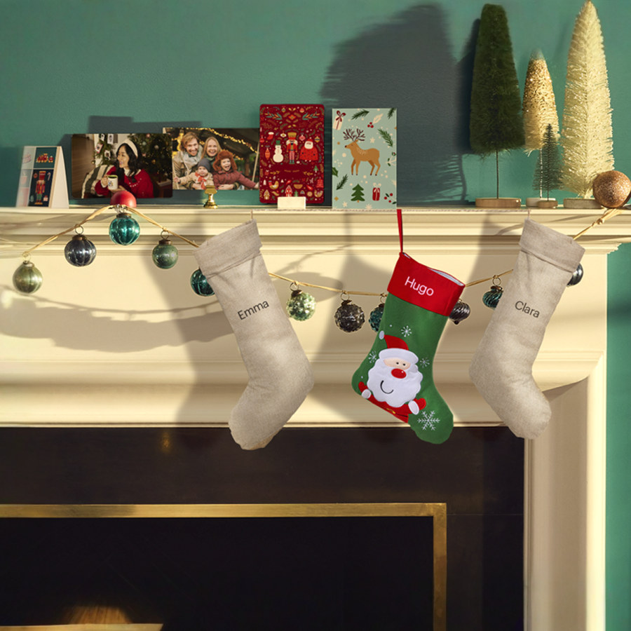 Três meias de Natal personalizadas penduradas numa lareira.