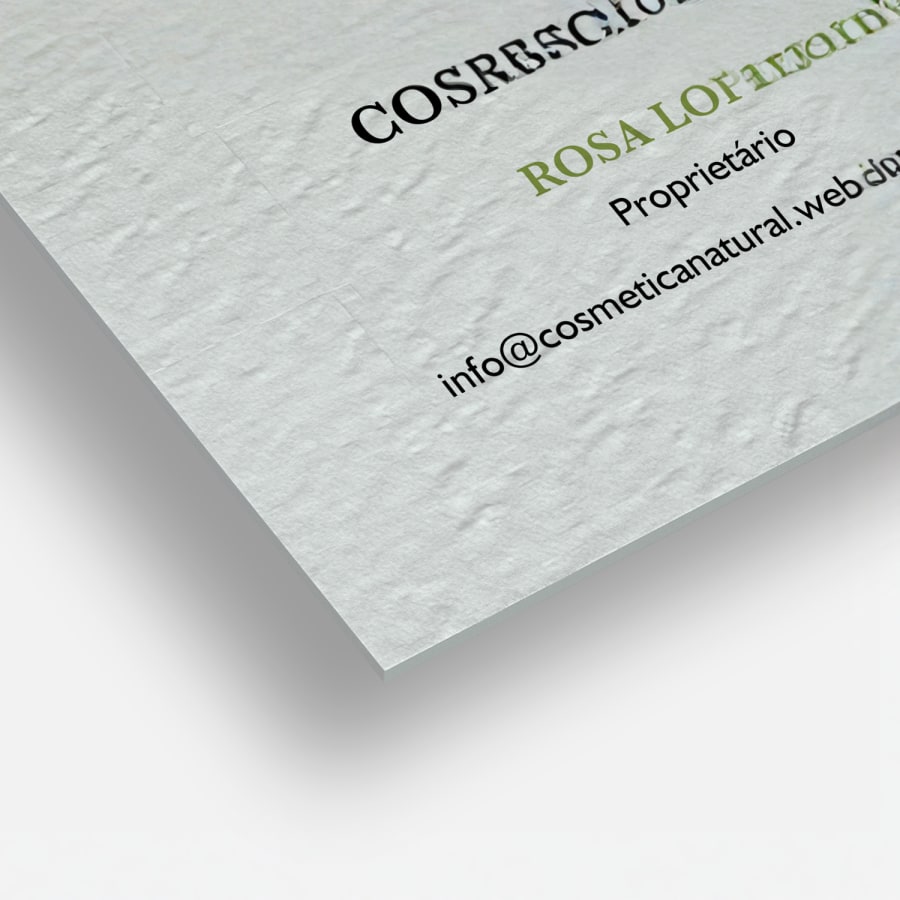 Uma fotografia de primeiro plano de cartões de visita texturizados sem revestimento, que mostra os cantos arredondados e o tipo de papel texturado semelhante a uma tela.