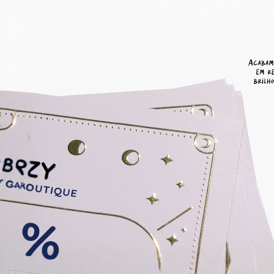 Imagem de primeiro plano de um cartão de visita, que mostra um logótipo com acabamento dourado em relevo e um texto.