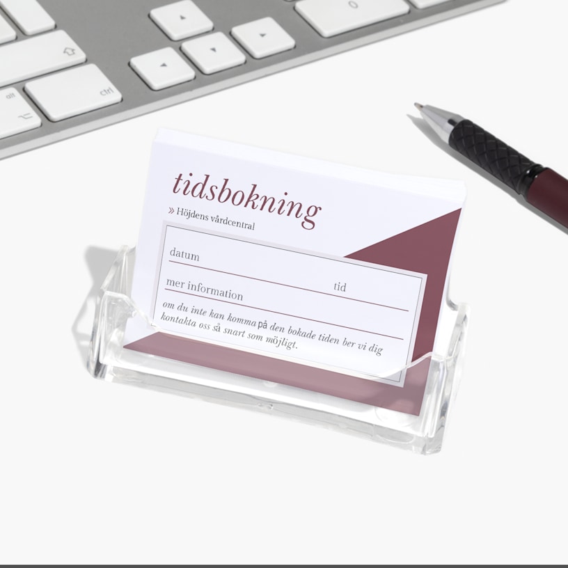 En visitkortshållare i akryl med tidbokningskort till en läkarmottagning.
