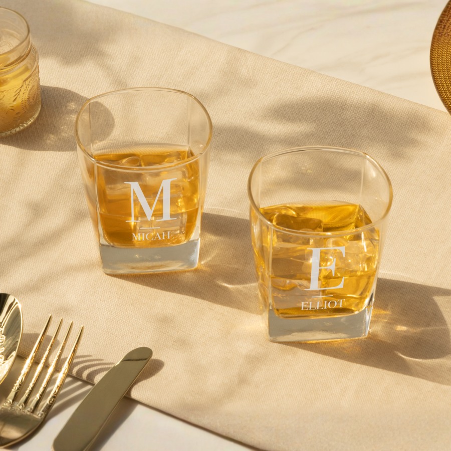 Two tumbler glasses personalised with a monogram and names.