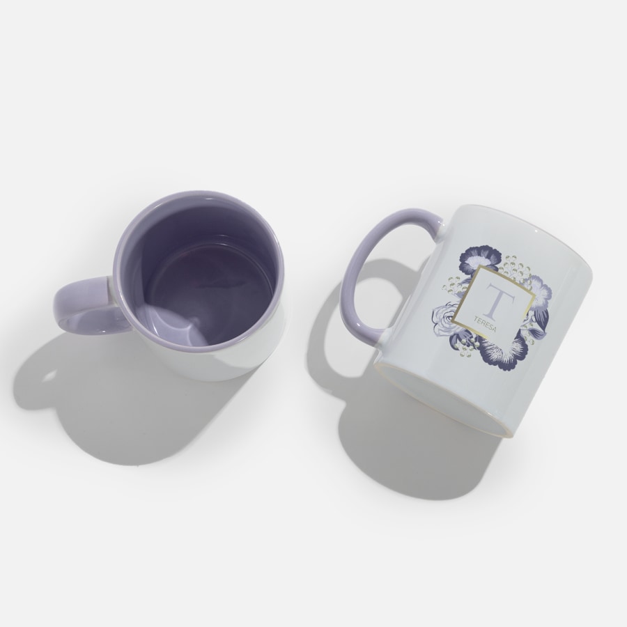 Two white and lilac mugs side by side, featuring a person’s monogram.