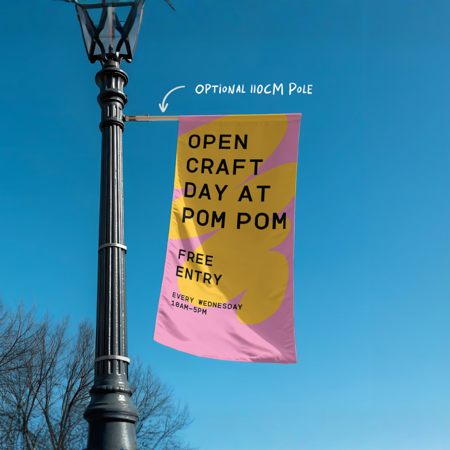 A wall flag promoting a craft business, mounted on a lamppost outdoors.