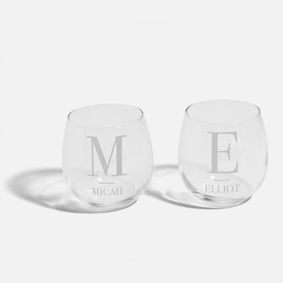 Two stemless wine glasses personalised with monograms and names.