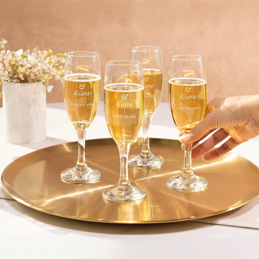 A set of 4 champage flutes for a wedding, personalised with the bride and grooms name and wedding date.