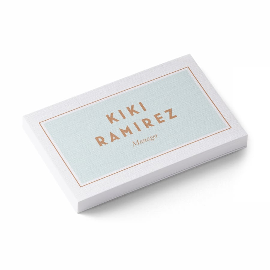 A stack of linen business cards for a manager named Kiki Ramirez.